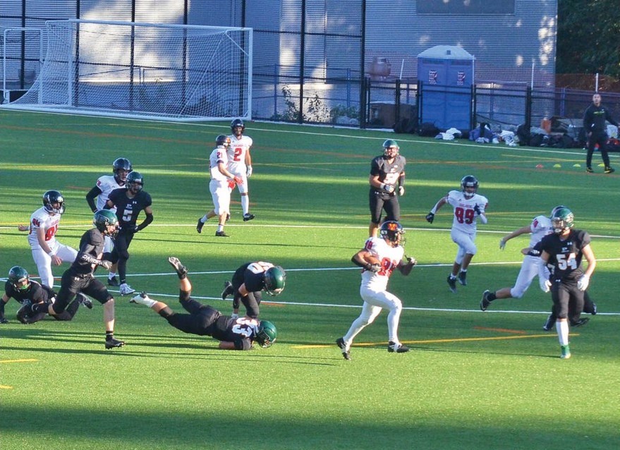 Two football teams in a play on a filed.